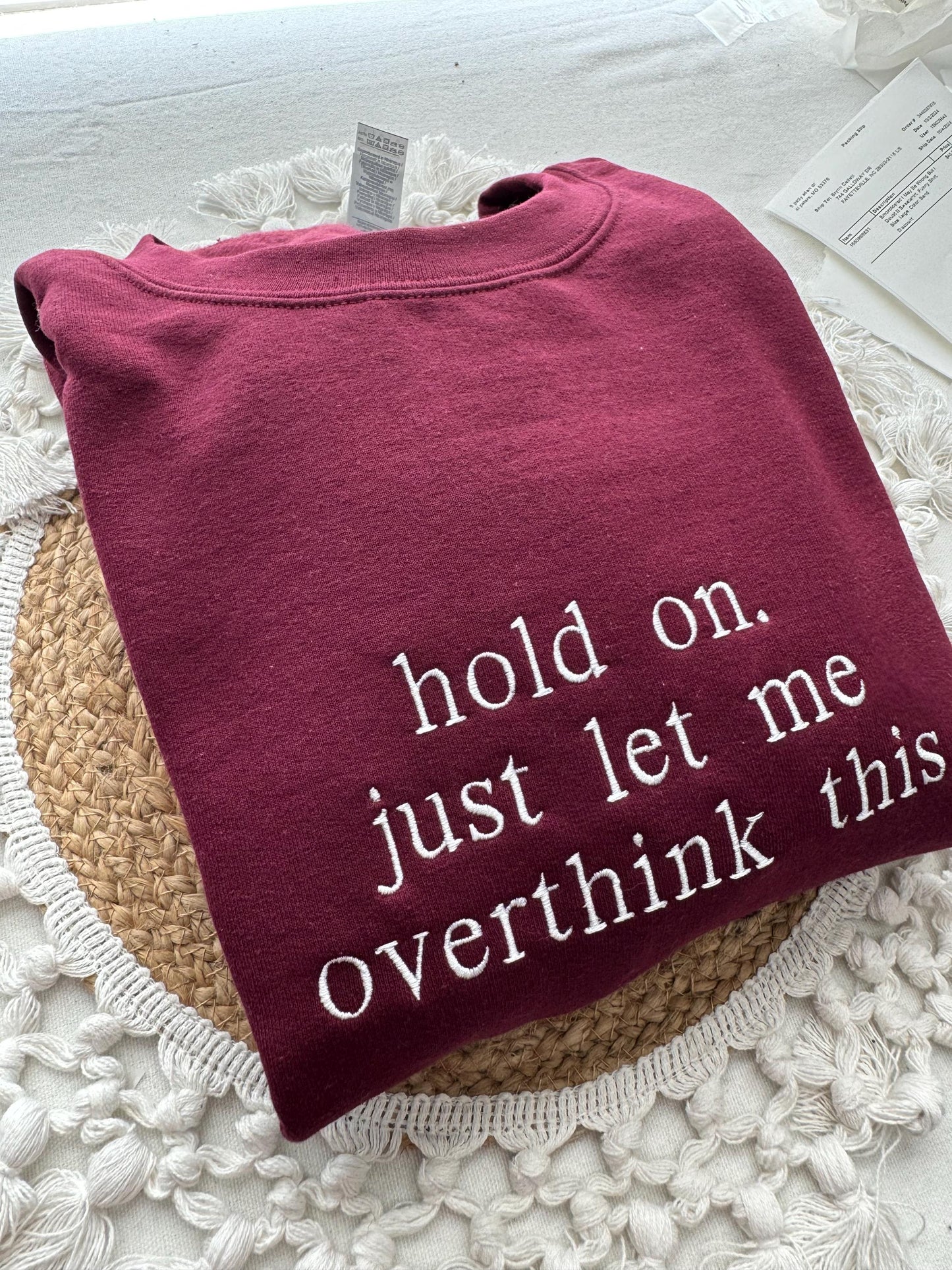 Maroon sweatshirt with "Hold On Let Me Overthink This" embroidered in white.