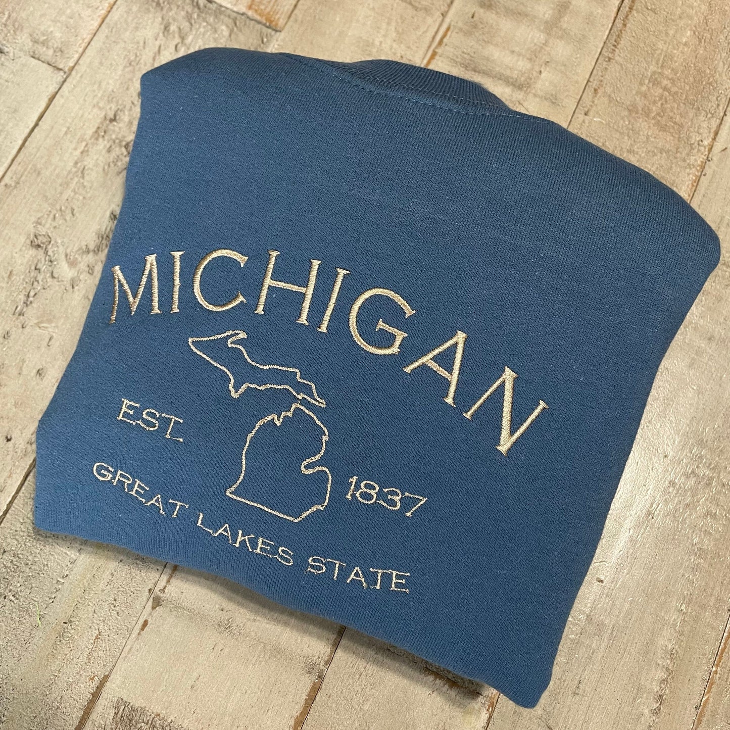 Michigan embroidered sweatshirt with Great Lakes design on blue crewneck.