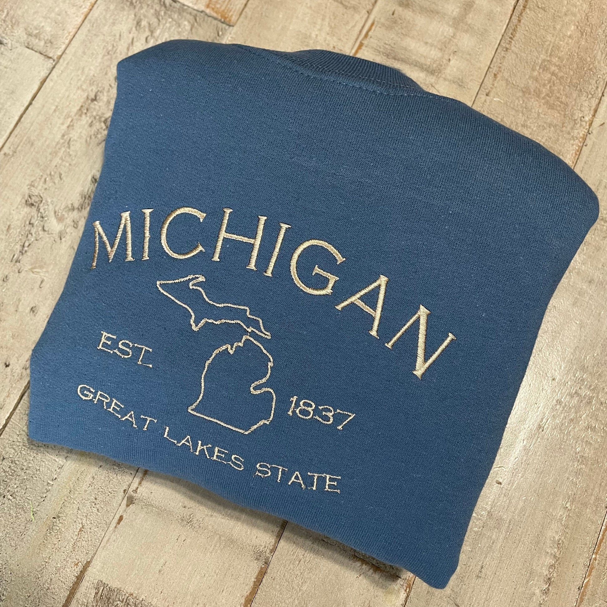 Michigan embroidered sweatshirt with Great Lakes design on blue crewneck.