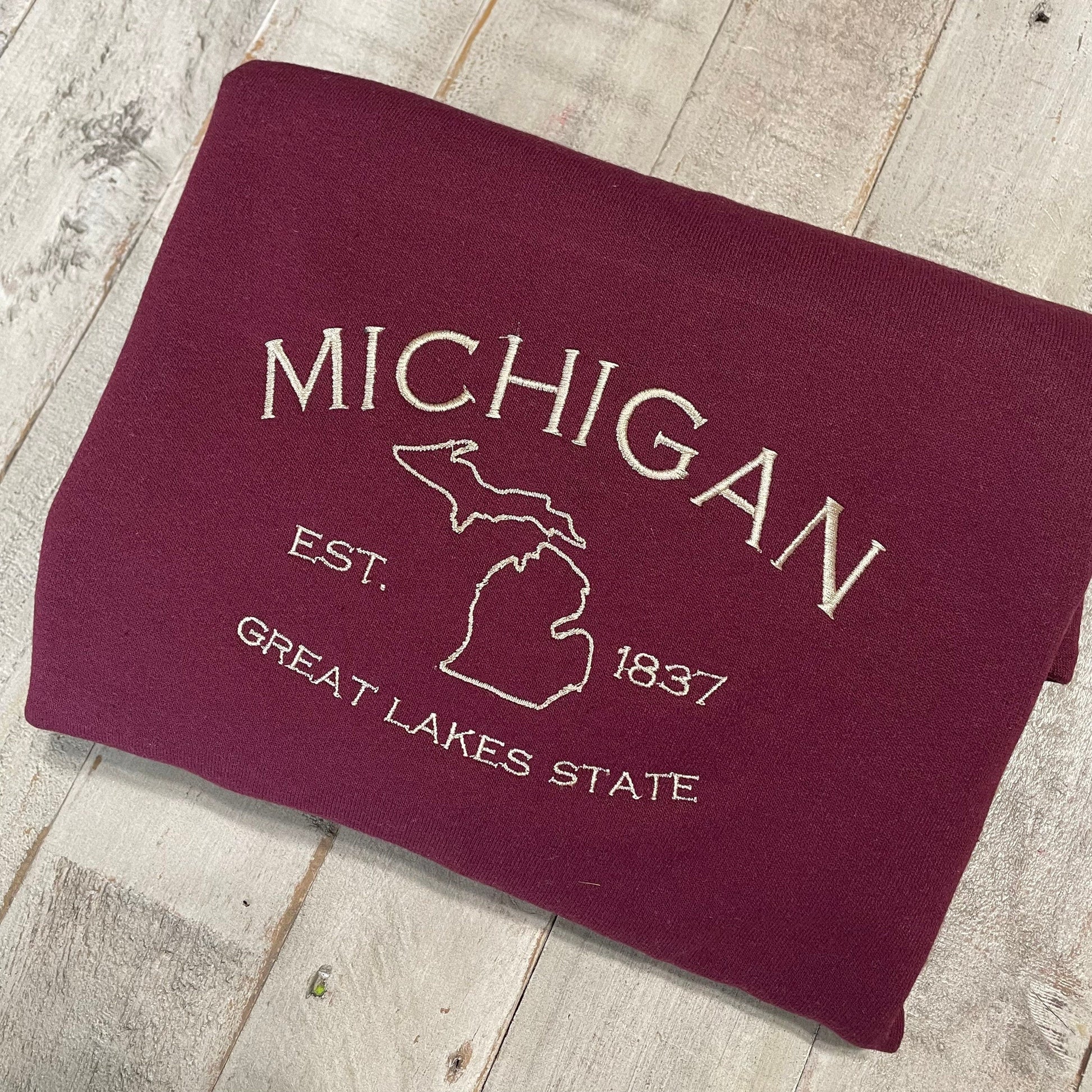 Michigan Embroidered Sweatshirt featuring Great Lakes design on a folded crewneck.