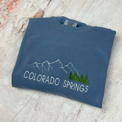 Comfort Colors Colorado Springs embroidered sweatshirt with mountain design.