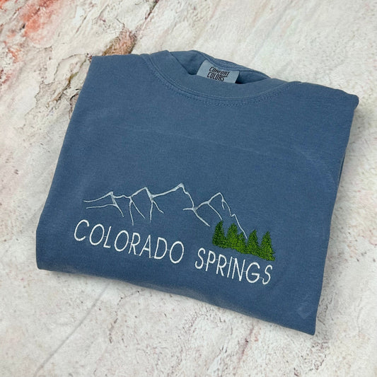 Comfort Colors Colorado Springs embroidered sweatshirt with mountain design.