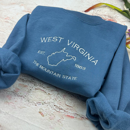 West Virginia embroidered crewneck sweatshirt in blue with state outline and text.