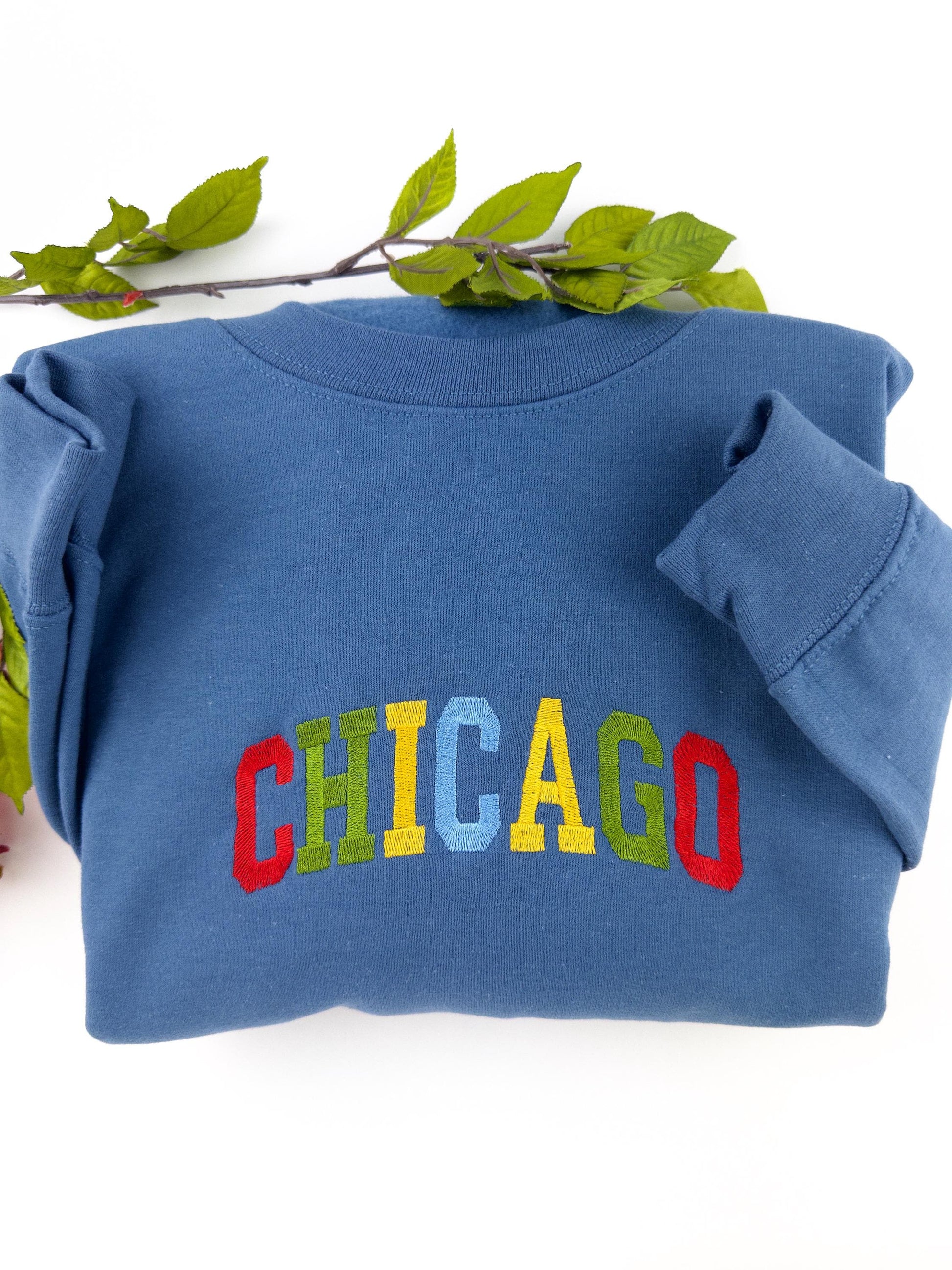 Colorful "Chicago" embroidered sweatshirt in blue with vibrant multicolored lettering.