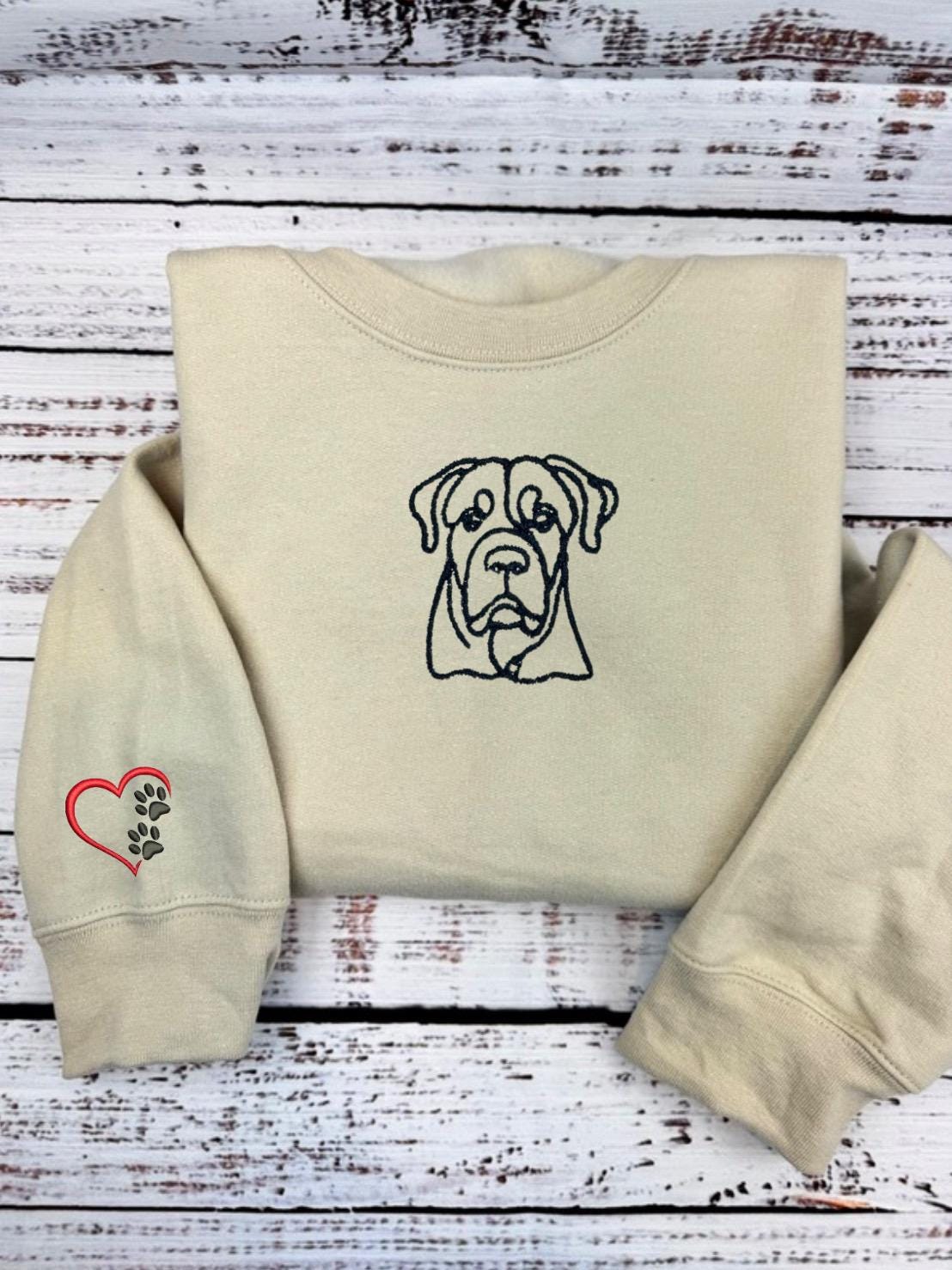 Custom dog embroidered hoodie with outlined dog design and heart paw sleeve decoration.
