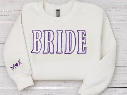 White bride sweatshirt with purple embroidery, customizable for bridal showers or wedding gifts.