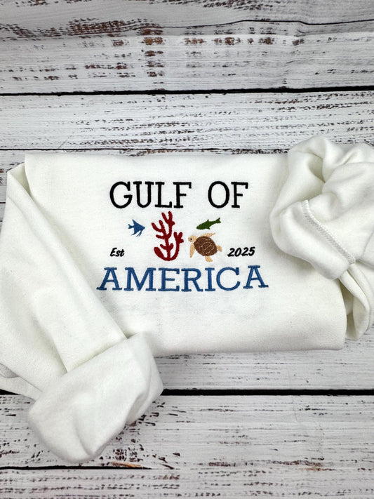 Gulf of America embroidered white sweatshirt with sea-themed design.