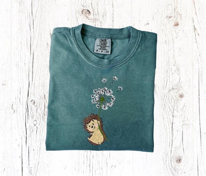 Embroidered hedgehog shirt with dandelion on green Comfort Colors tee, perfect for nature lovers.