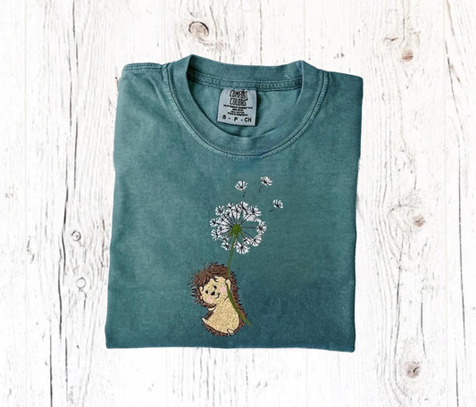 Embroidered hedgehog shirt with dandelion on green Comfort Colors tee, perfect for nature lovers.