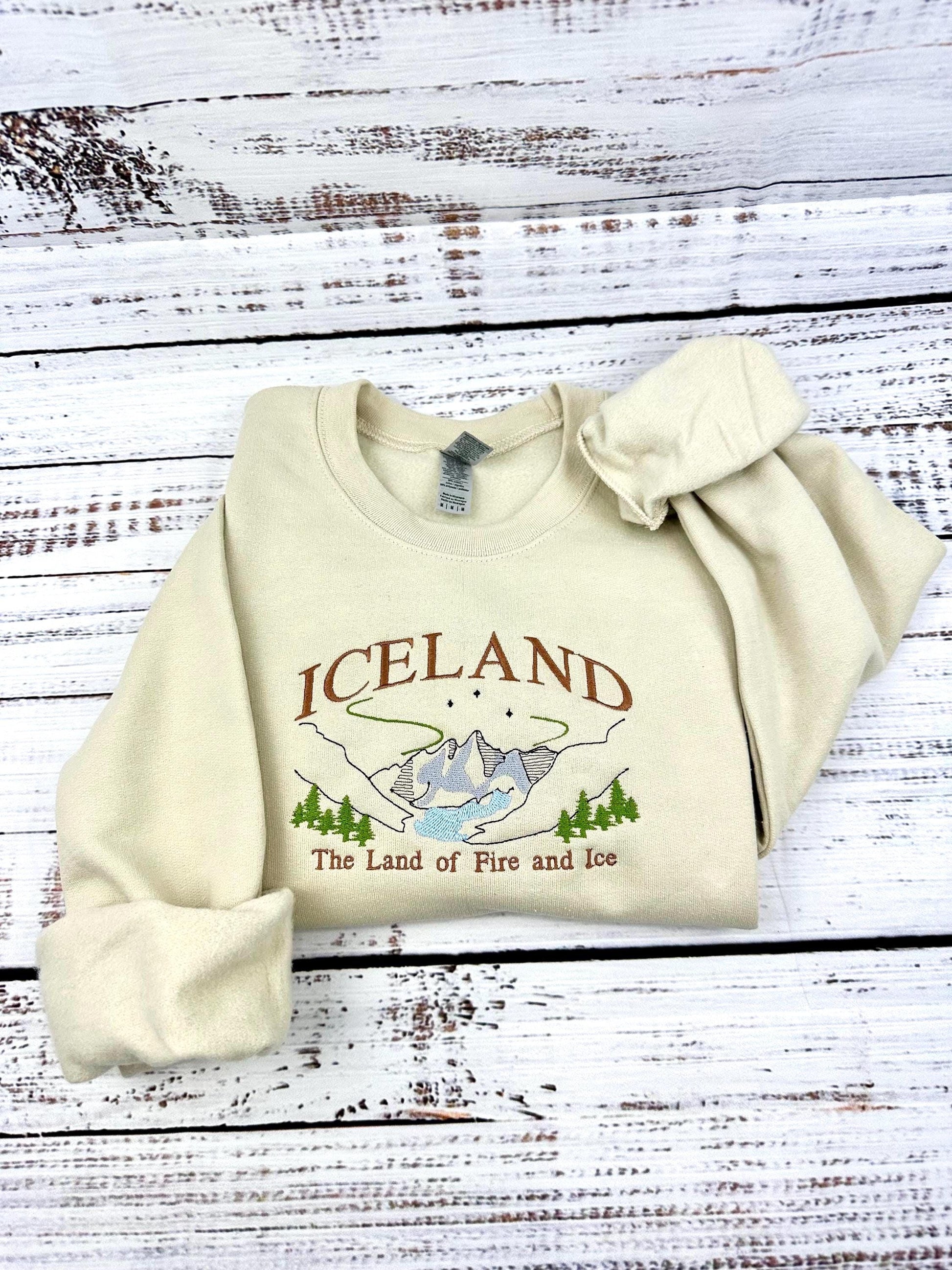 Iceland embroidered sweatshirt with Nordic mountains and aurora design, labeled "Land of Fire and Ice."